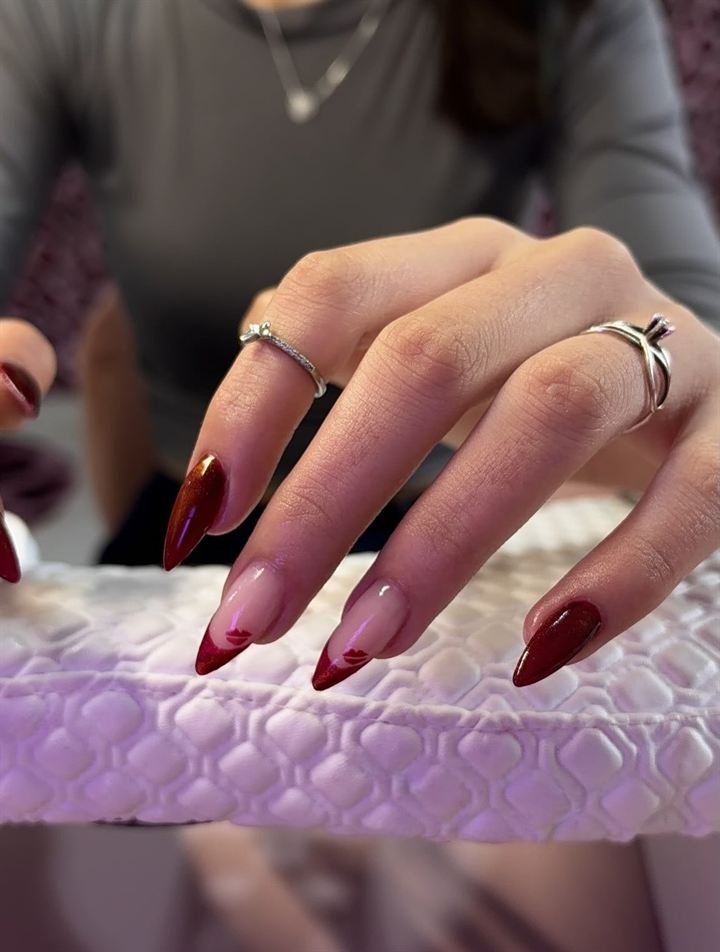 Mãos com alongamento amendoado em vermelho com francesinha, trabalho da BN Nails